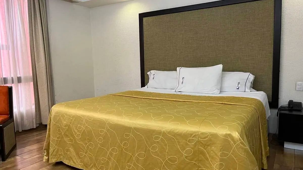 Habitación Suite Estándar con cama king size con una mesa con dos sillas.